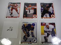 Five hockey rookie cards laid out flat on white background with a card showing number 26 for lot identification. Players include Paul Blue, Mike Ricci, Gino Odjick, Rod Brind'Amour, and Rob Blake.