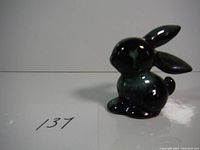 Front angled view of the small ceramic bunny figurine showing upright ears and smooth glossy finish.