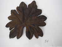 Top view of cast iron leaf piece showing detailed veins and brown patina.