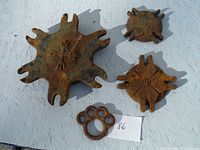 Four rusted cast iron pieces displayed on white surface with numbered tag 86