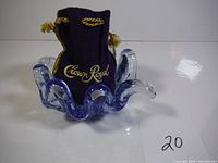 Blue glass flower-shaped bowl with crown royal bag inside, showing curved petal edges and blue tint