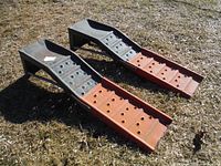 Pair of extended car ramps placed on grass, showing the top and side profiles of the ramps.