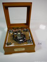 The music box opened showing the train and winter village scene inside with snow-covered trees and figures around the tracks.