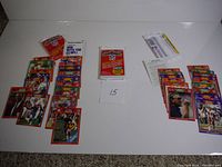 Overview of multiple opened player cards laid out alongside one unopened pack and two opened sealed packs of 1989 NFL Football Cards.