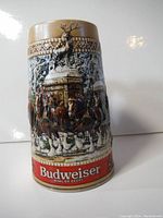 Front view of vintage Budweiser ceramic beer stein with embossed winter scene, Budweiser logo at base.