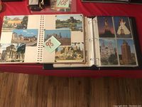 Open view of postcard collection showing postcards inserted in photobook and binder plastic sleeves.