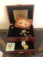 Wooden United States Army commemorative box open showing compartments, Soldier's Creed inside lid plaque, pocket watch and various pins inside