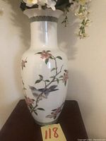 Tall white porcelain vase with hand-painted bird and cherry blossom branch detail, scalloped decorative rim, and glossy finish.