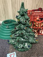 Close-up of ceramic Christmas tree without lights illuminated to display bulb colors and tree texture.