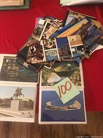 Loose postcards and postcards in photo sleeves showing locations and cultural scenes.