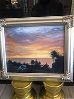 Original framed painting of sunset and palm trees in silver frame.