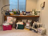 Overview photo of the sewing and craft items placed on and beneath a wooden desk with various bins and packaged fiberfill.