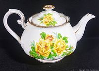 Side view of 1940's Royal Albert tea pot showing detailed yellow rose floral pattern and gold trim