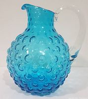 Front view of the large aqua hobnail glass pitcher showing texture and spout.