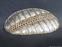 Front view showing hammered silver-tone metal surface split by central applied brass textured strip in Brutalist style