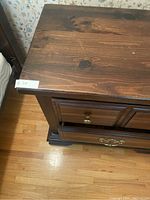 Close-up of top portion showing wood grain and drawer knobs