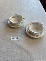 Two Royal Worcester Harvest ring teacups and matching saucers placed on a textured light tablecloth, showing overall condition and detail.