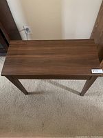 Top view showing the flat wooden surface of the small table with a medium brown finish.