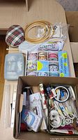 Kit contents including wooden embroidery hoops, multi-colored threads, pincushion, rulers, sewing needles, and scissors.