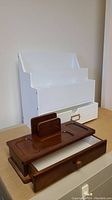 White painted wood desk organizer showing multiple compartments and two drawers.