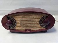 Front view of 1950 Sparton tube radio with visible volume and tuning knobs and woven speaker grille.