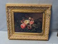 Full view of the framed floral canvas print showing the outer decorative gold-tone frame with visible damage and the artwork inside.