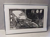 Framed black and white abstract ink print photographed from an angle to show detail and size.