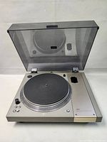 Top view of silver OTTO TP-1000D turntable showing open dust cover, rubber platter mat, missing tonearm area.
