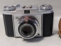 Front and angled views of the Zeiss Ikon camera showing the lens details and brand logo.