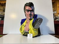 Front view of painted plaster Elvis bust showing face, jacket and neoprene pad