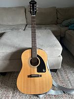 Front view of guitar body showing spruce top, pickguard and bridge