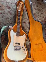 Full-length Fender Bronco electric guitar in open orange plush-lined hardshell case