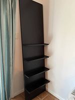 Front view of the seven foot tall leaning wood shelf with four shelves, showing overall appearance and color.