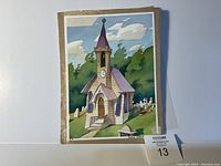 Hand-painted animation background painting featuring a church with a purple roof, clock on tower, greenery, gravestones, and blue sky with clouds. Painting is unframed and shows slight edge wear.