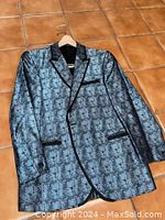 Front of blue patterned silk evening jacket with black trim