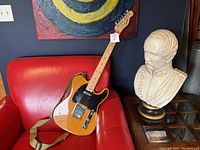 Full view of guitar on chair with strap attached