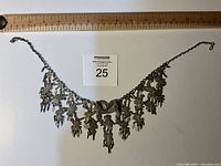 Full view of the vintage filigree necklace approx 18 inches long with a ruler for scale