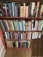 Three shelves filled with paperback and hardcover books