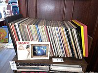 Side view of shelf with rows of vinyl album spines and front-facing covers