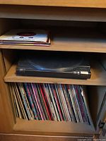 Overview of turntable on shelf above LP records