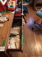 Two drawers open showing neatly folded scarves and gloves inside, arranged in rows with tags.