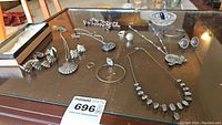 Full assortment of sterling silver jewelry displayed on glass table