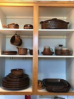 Full cabinet view showing top shelf with small sauce boat, small bowl and large round lidded casserole