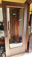 Photo of wooden door with etched glass showing geometric starburst patterns and brass handle