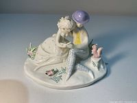 Front and side angle of Rosenthal porcelain figurine showing seated lady and gentleman reading, with wildlife details.