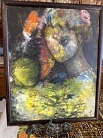 Full view of framed abstract oil painting on board showing colorful human-like faces and textured colors in dark wood frame.