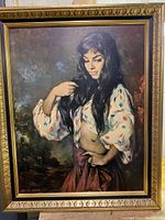 Full view of framed print showing woman with long hair, blouse with polka dots, red skirt, and gold decorative frame.