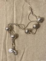 Full view of the bracelet laid out showing textured beads and clasp with 925 charm