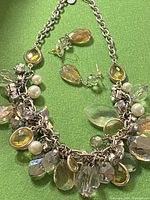 Photo of necklace and matching earrings, showing the multicolored teardrop and round charms with faux pearls and silver-tone chain