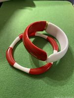 Two vintage Lucite cuff bracelets posed together showing color and form.